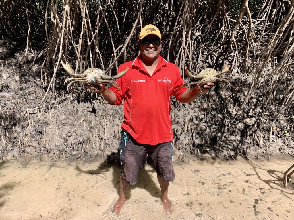 Tour guide holding up crabs