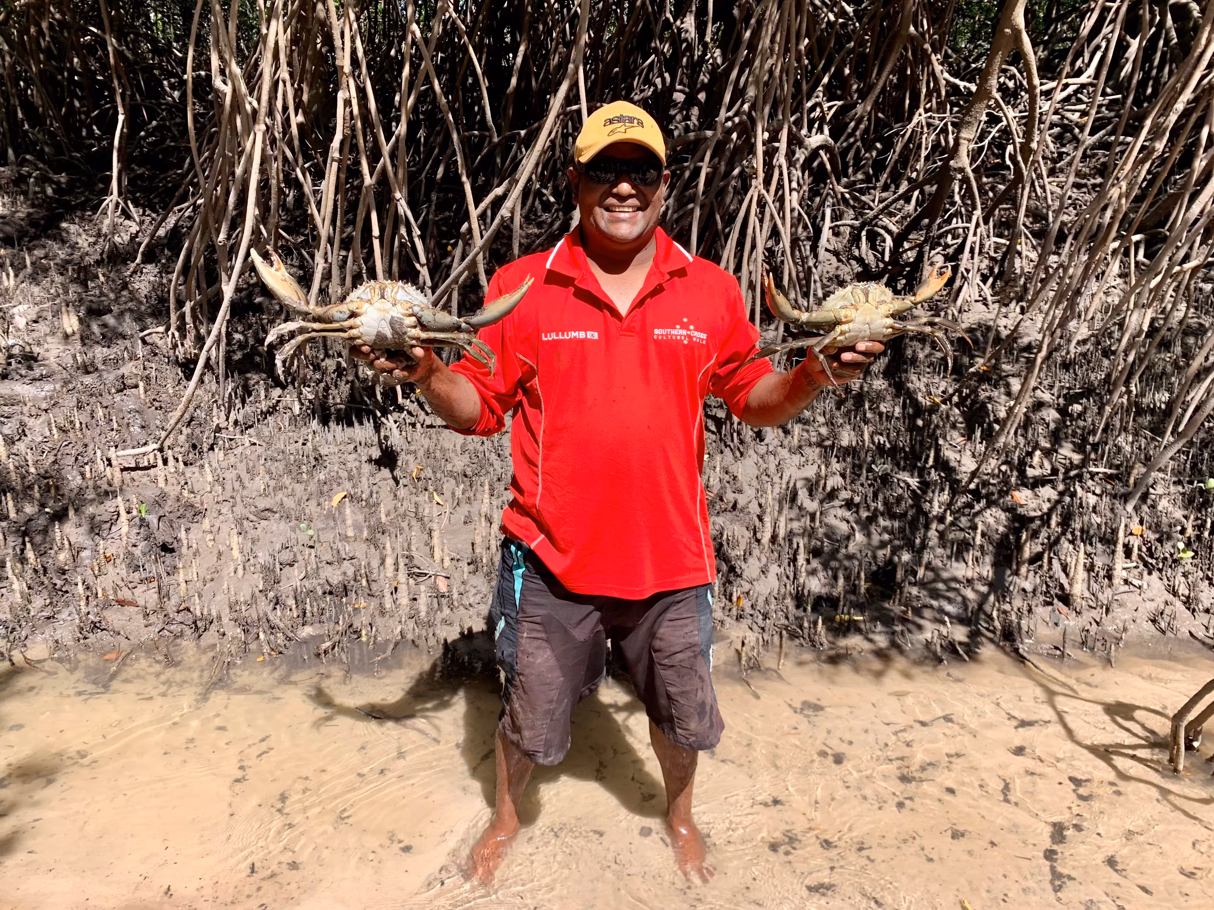 Tour guide holding up crabs