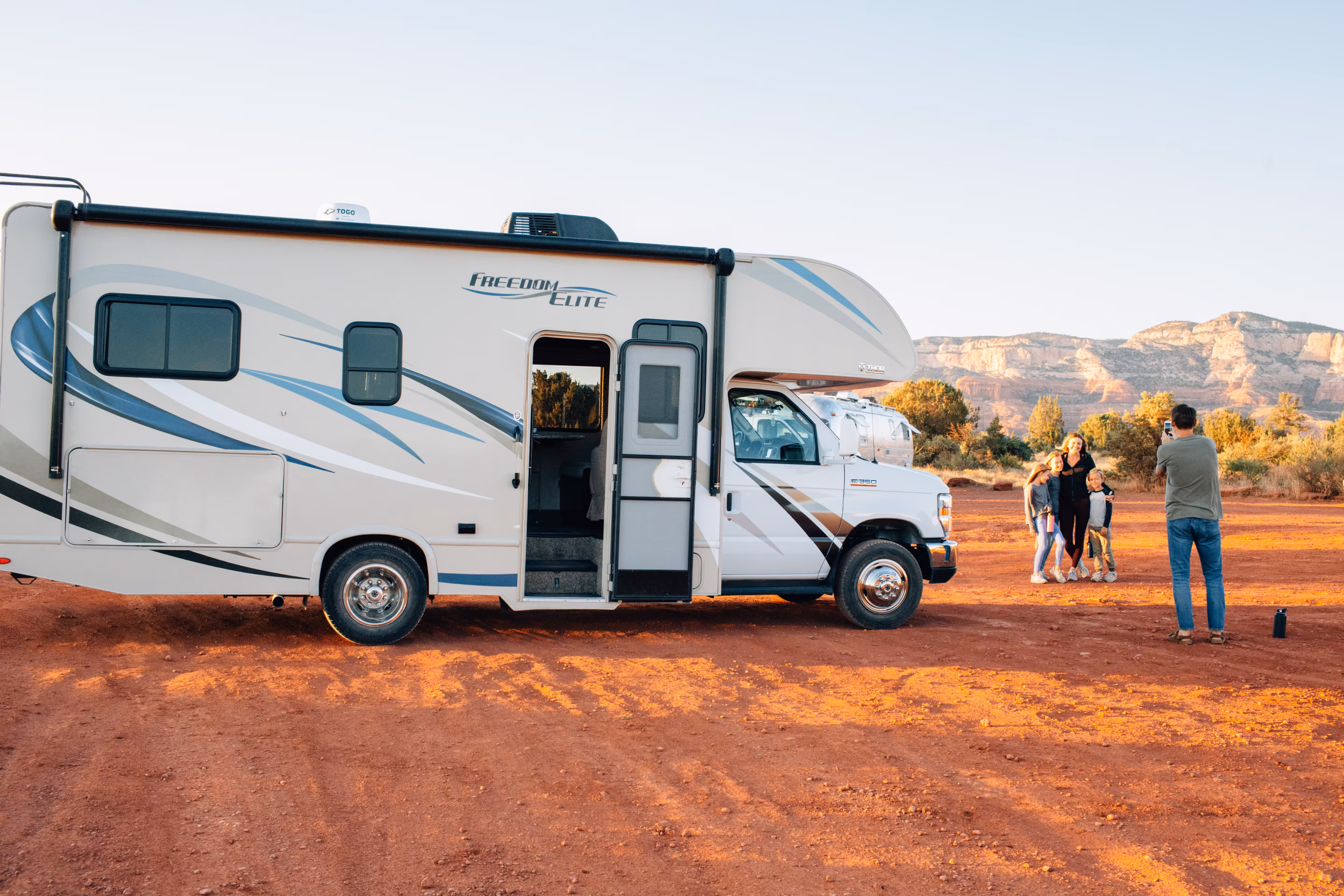 Family taking a photo next to their RV