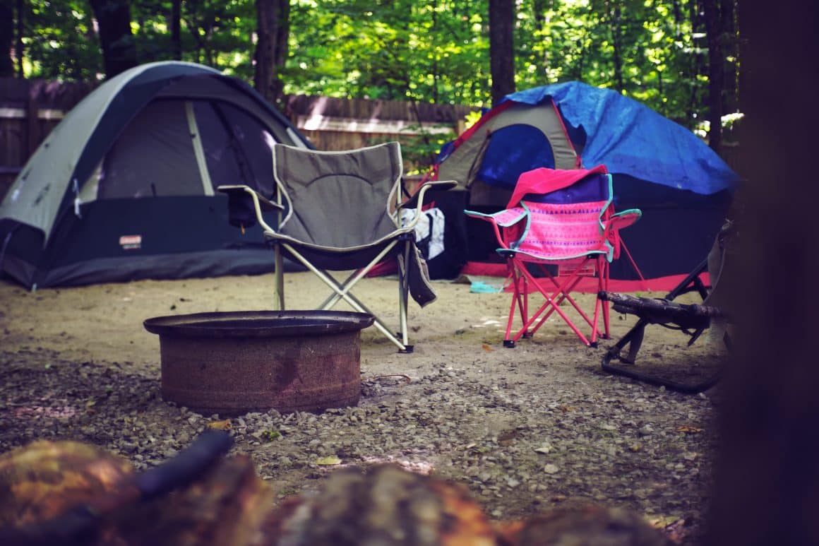 Traditional camping setup with tents and camp chairs showing glamping vs camping options
