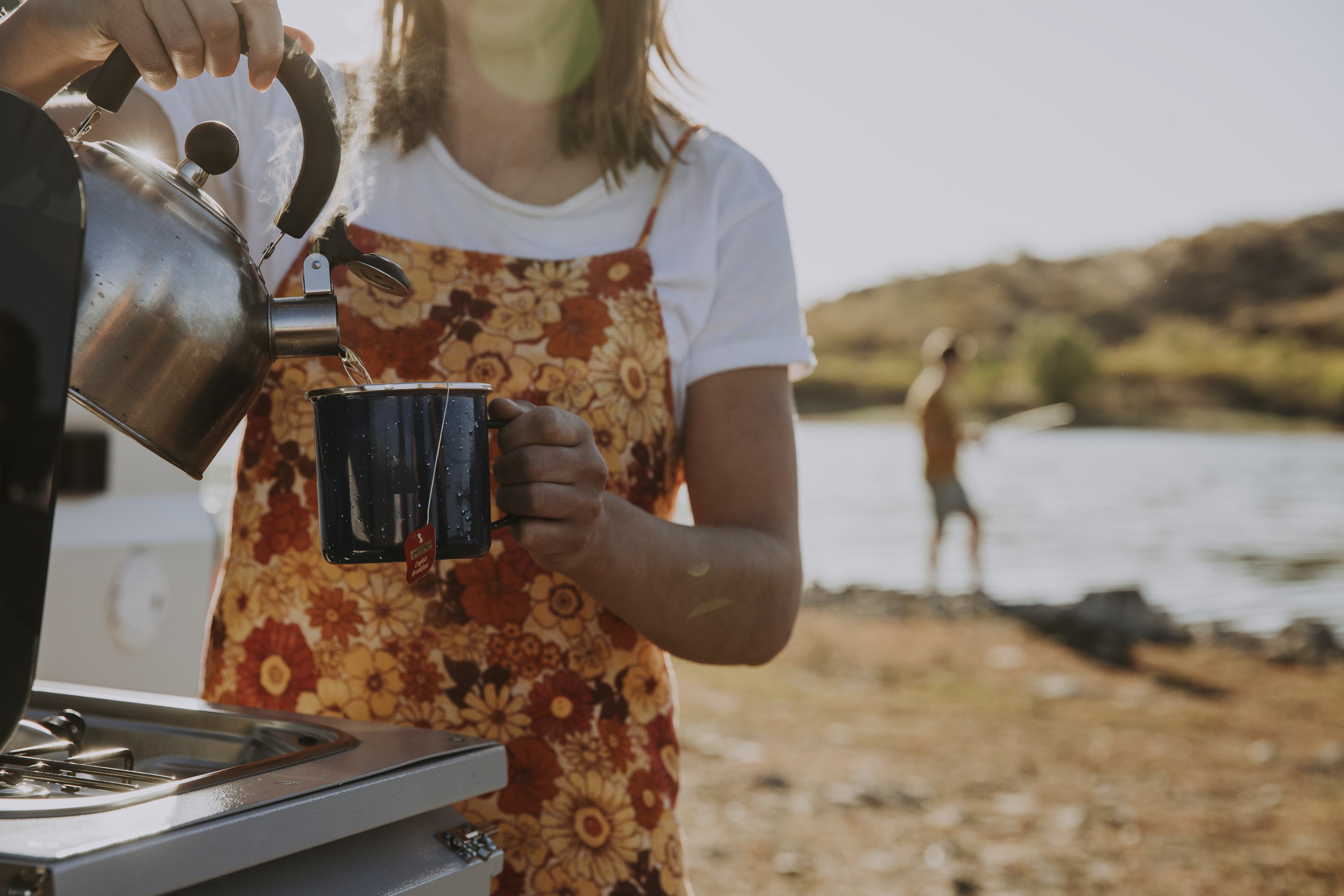Woman pouring coffee camping